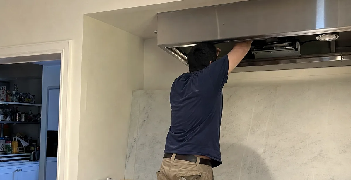 Left of a hood service: the doorway into the next room, the counter and the technician on his step stool
